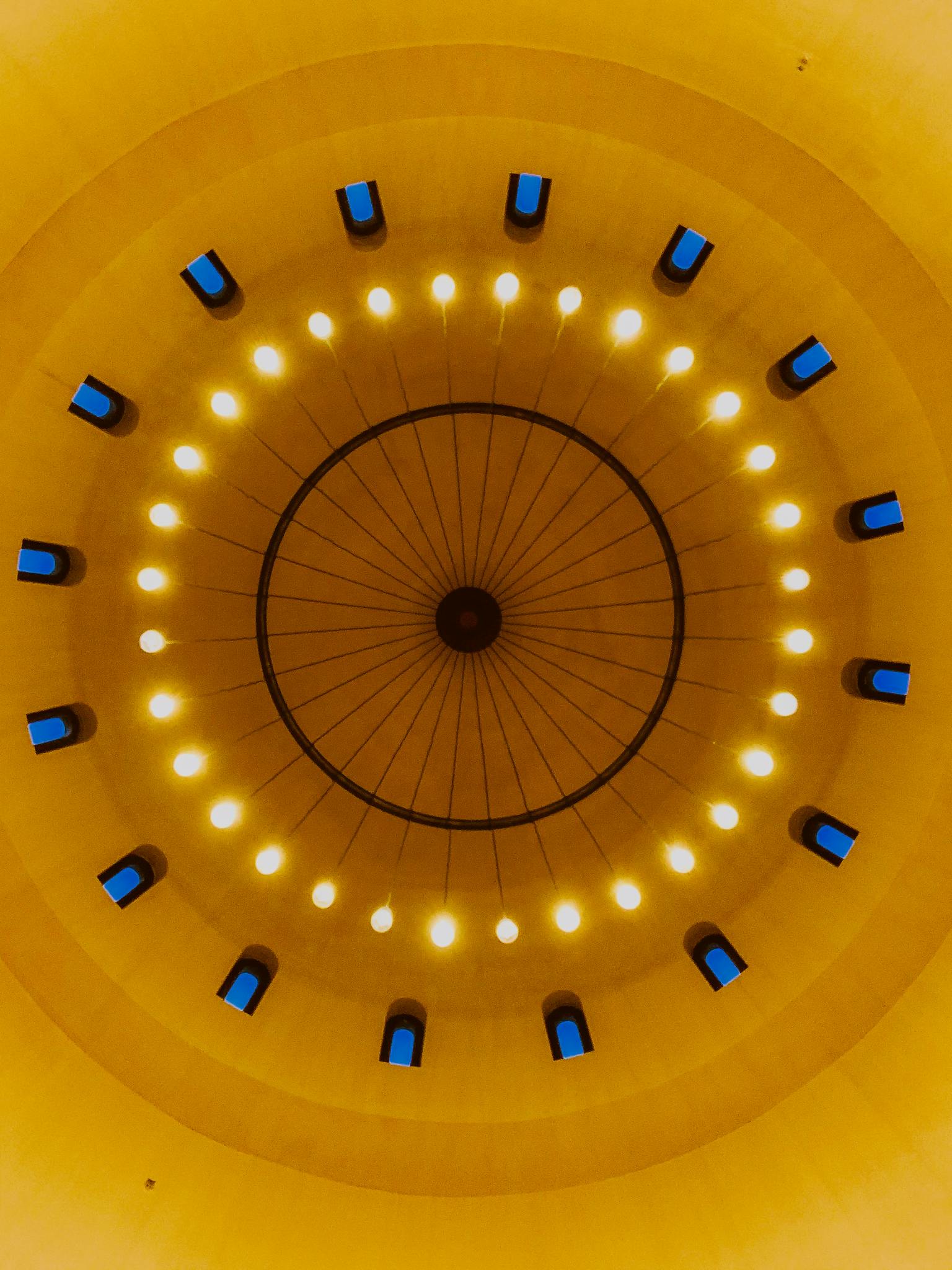 Striking view of an ornate dome ceiling featuring symmetrical circular lighting and vibrant colors.